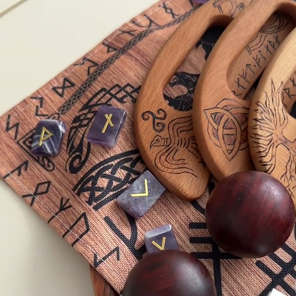 Boules de bois et gua sha posés sur le tapis brodé de runes